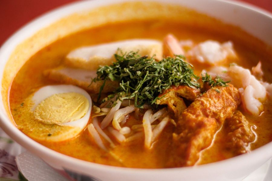 Nyonya Laksa in a rich coconut-based broth with traditional toppings