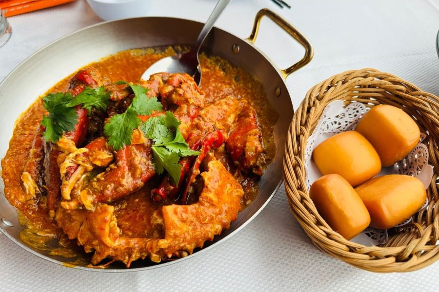 A plate of Singaporean chili crab served with fried mantou buns